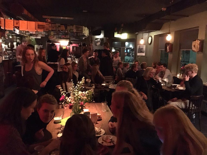 Eten, drinken en naast elkaar zitten aan de grote tafels.
