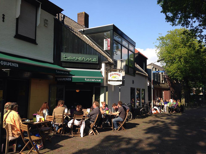 Op een zonnige middag zit het terras vol, midden in het centrum.